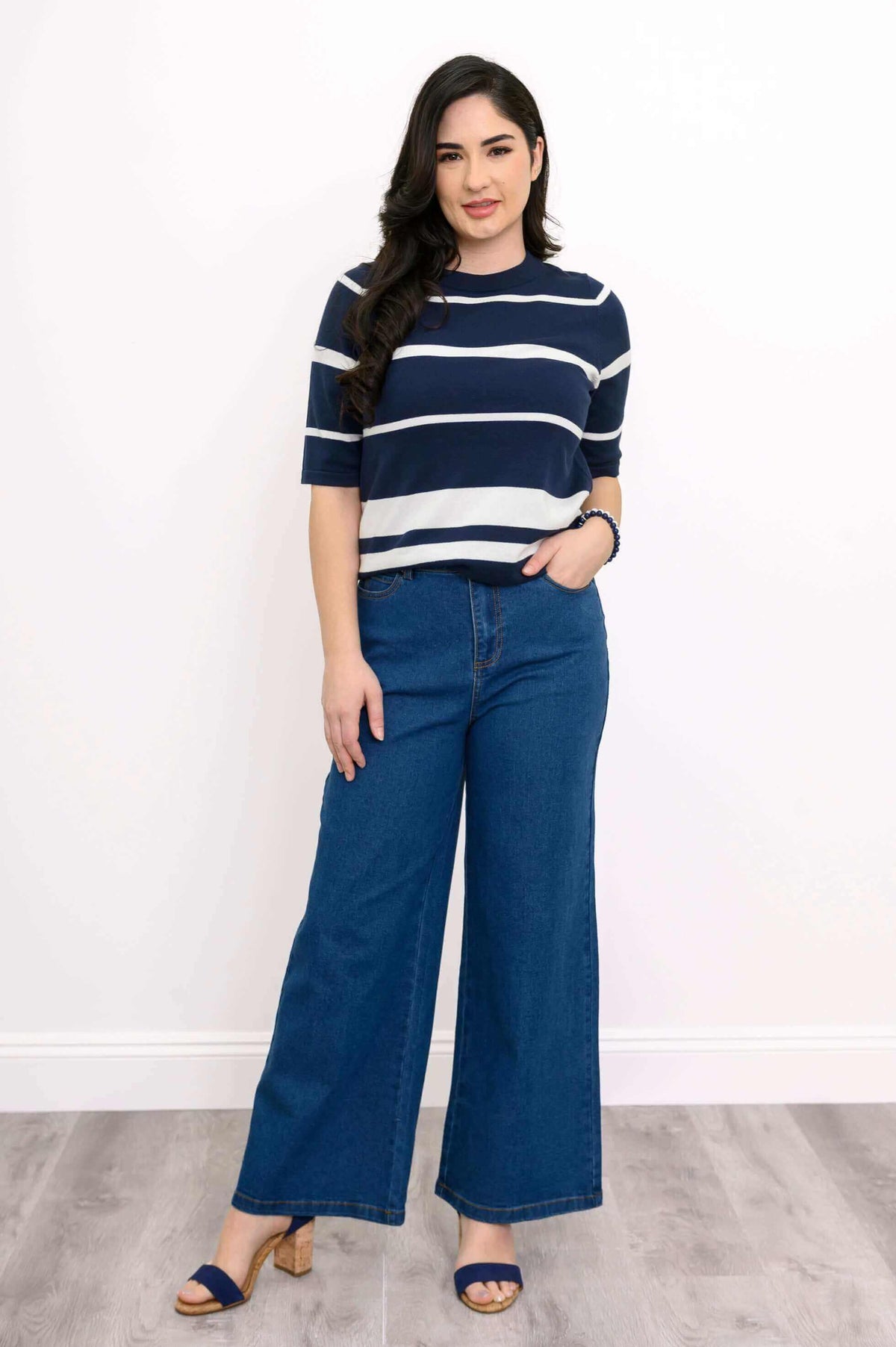 Front view of woman wearing navy and white striped Serena Sweater with wide-leg jeans
