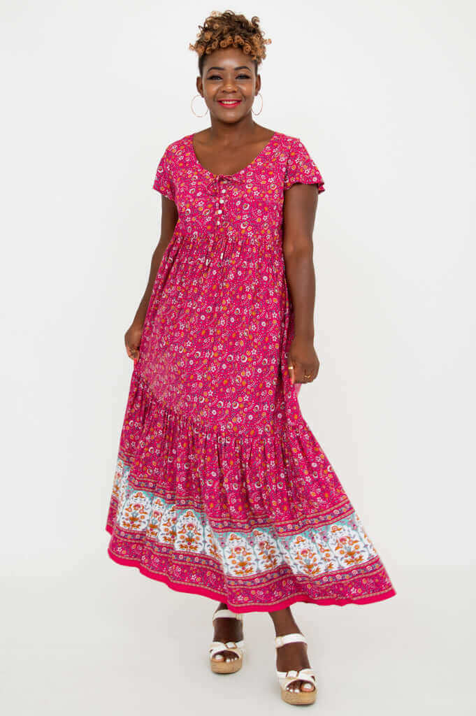 Front view of model wearing a vibrant pink floral maxi dress with flutter sleeves