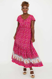 Front view of model wearing a vibrant pink floral maxi dress with flutter sleeves