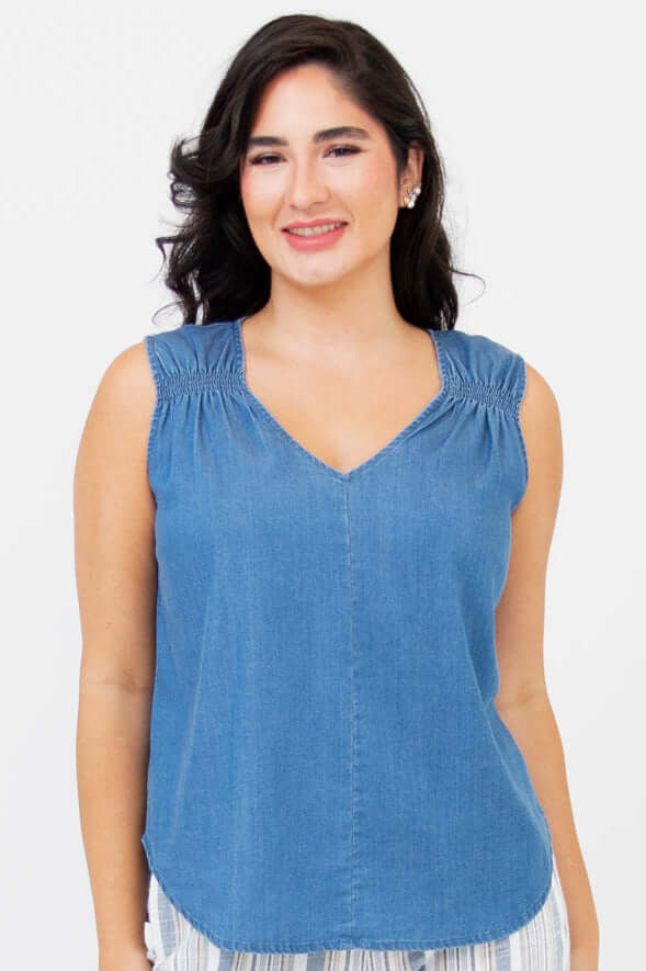 Front view of woman wearing a sleeveless blue Tencel tank top with shirred straps