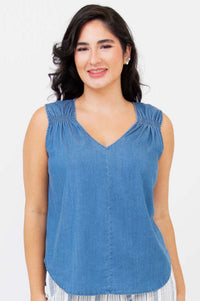 Front view of woman wearing a sleeveless blue Tencel tank top with shirred straps