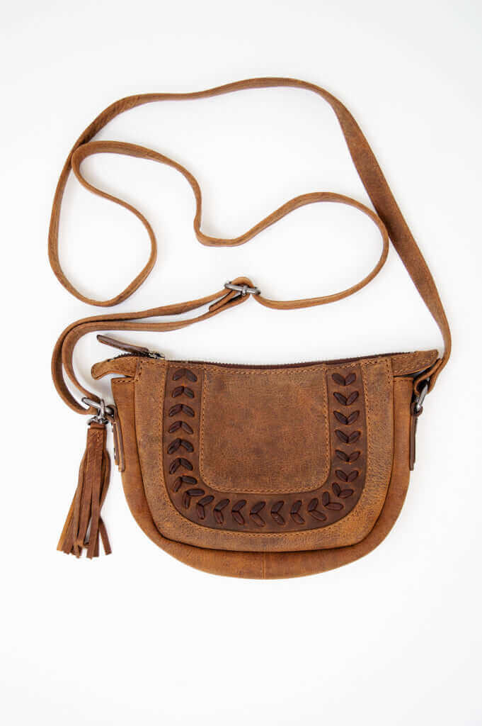 Front view of Terra Rustic Crossbody Bag with decorative stitching and tassel