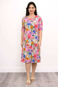 Front view of woman wearing a knee-length, colorful floral bamboo dress