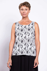 Front view of a woman wearing a sleeveless black and white floral tank top