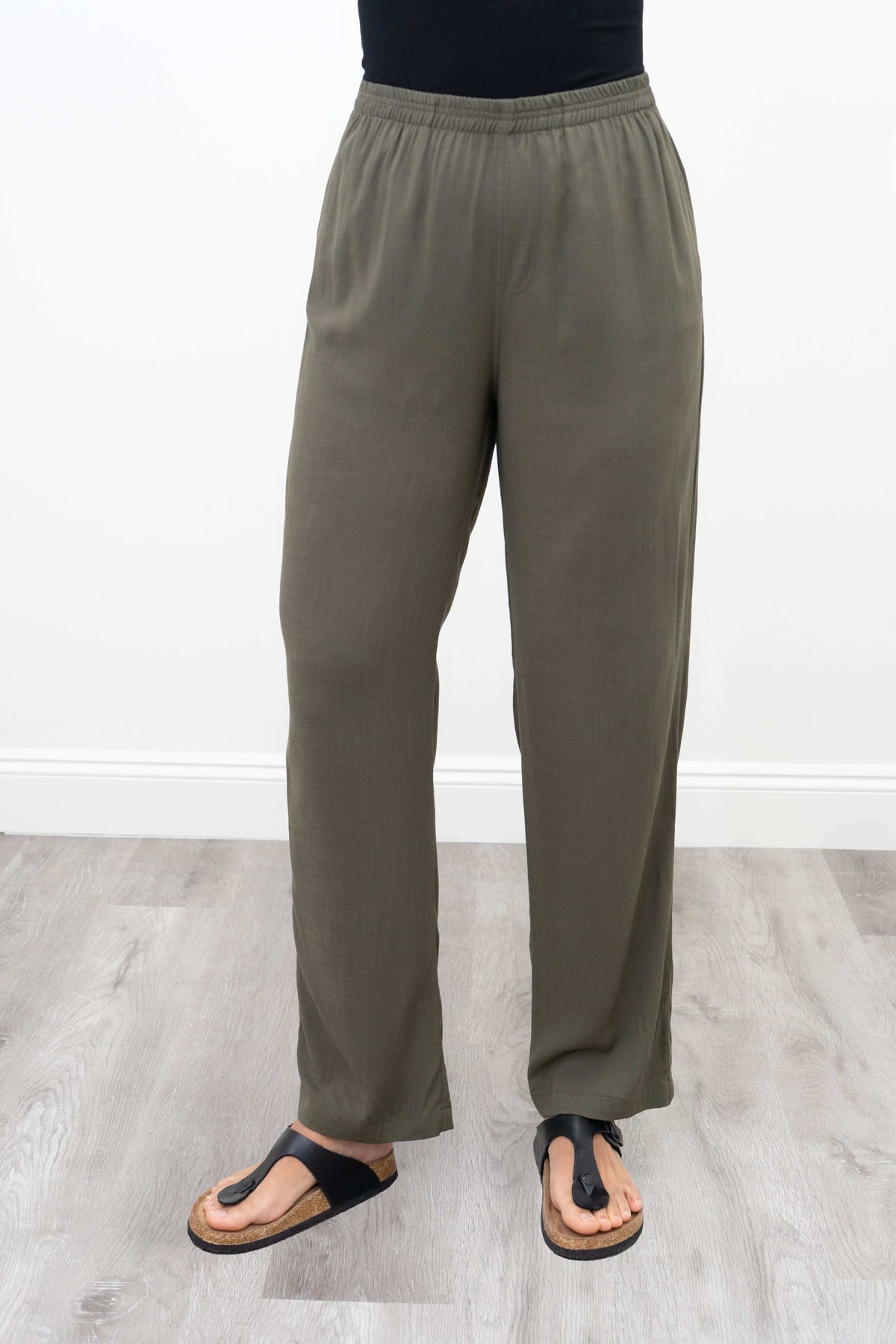 Front view of relaxed fit olive green bamboo linen pants on model