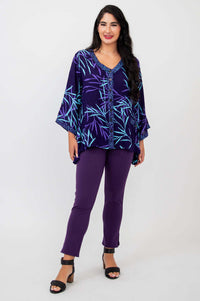 Front view of woman in purple bamboo tunic top paired with purple pants and black sandals