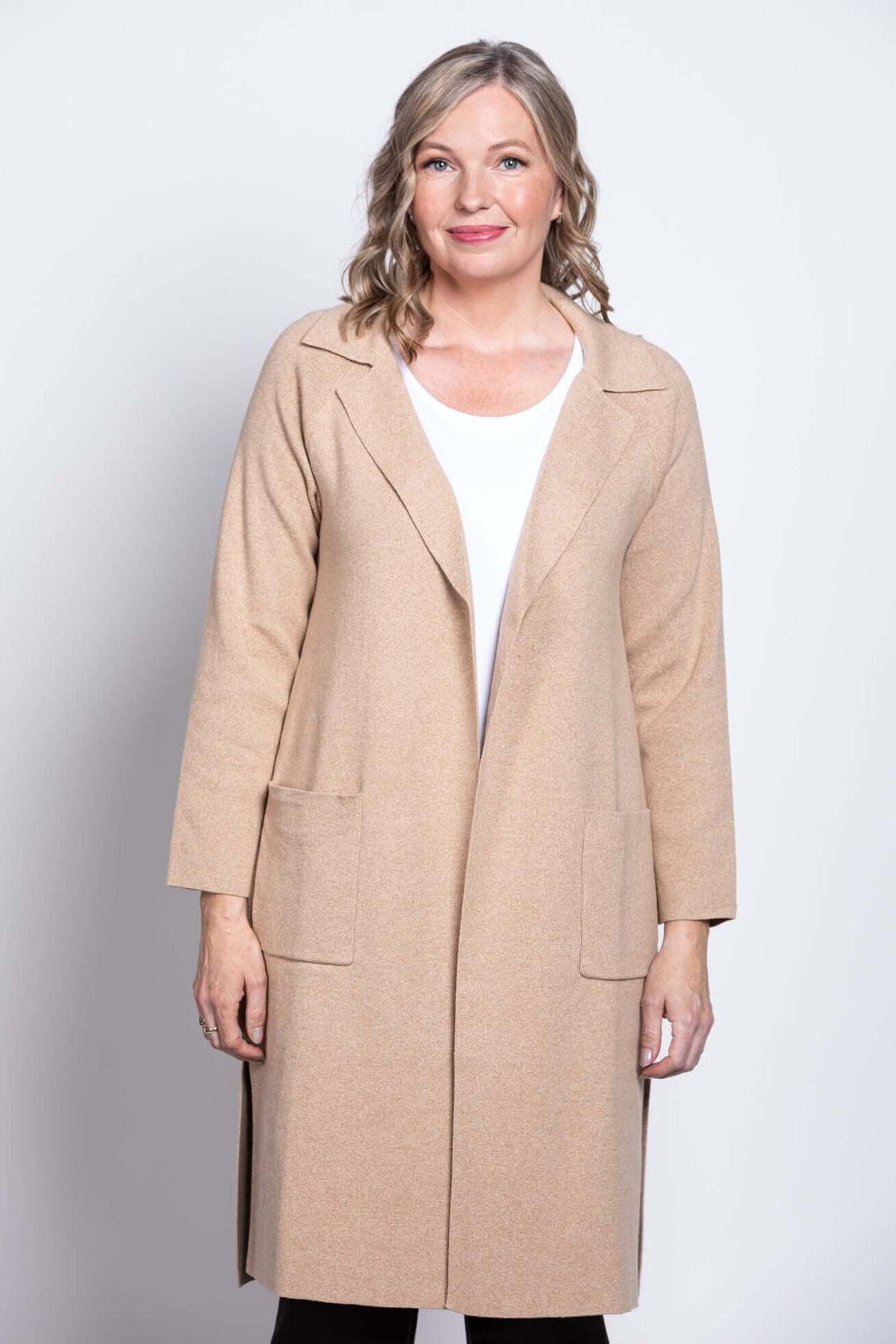 Front view of a woman wearing a beige open front cotton jacket with pockets