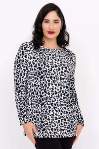 Front view of woman wearing a long sleeve black and white animal print tunic top