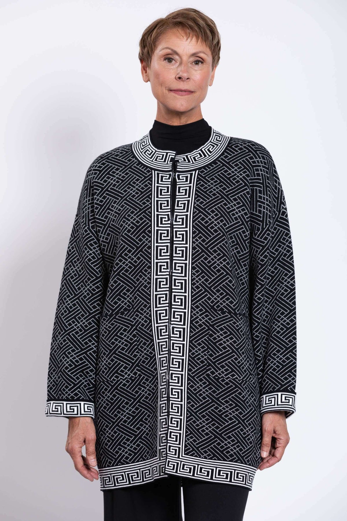Front view of a model wearing a black and white geometric cardigan with mandarin collar
