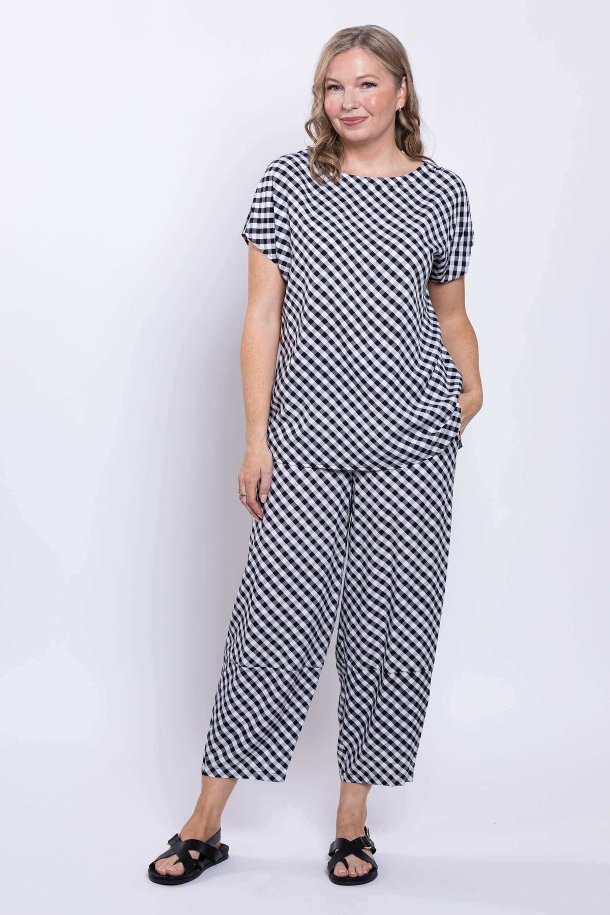 Front view of woman modeling black and white gingham tee with matching pants