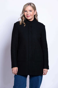 Front view of a woman wearing a black boiled wool coat with patch pockets