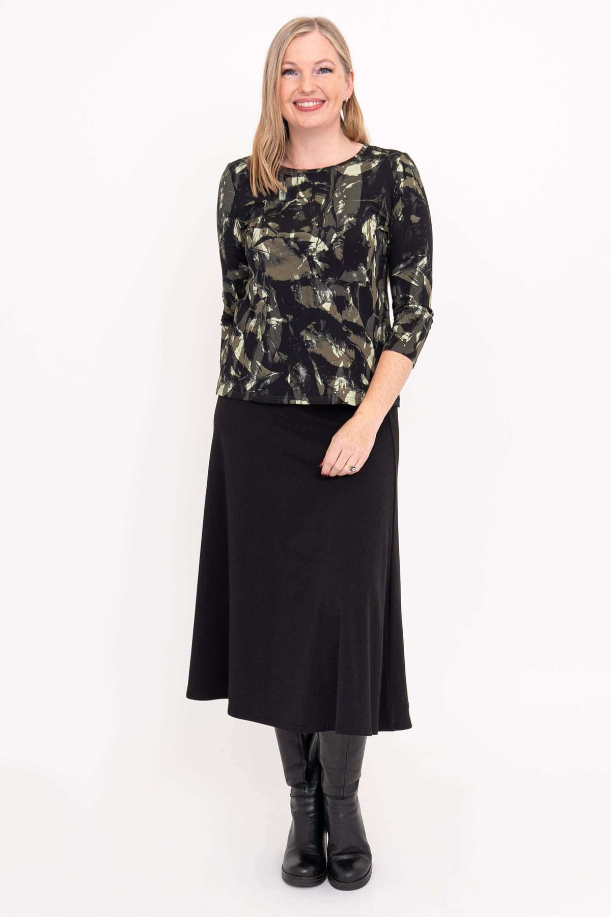 Front view of woman in black brushstroke 3/4 sleeve top and black skirt