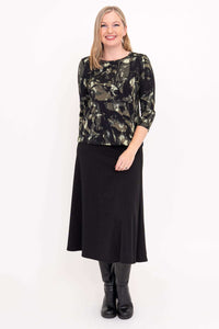 Front view of woman in black brushstroke 3/4 sleeve top and black skirt