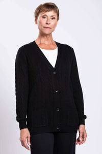 Front view of a woman wearing a black cable knit cardigan with V-neck and patch pockets