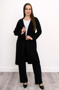 Front view of model wearing black open front cotton knit jacket with pockets