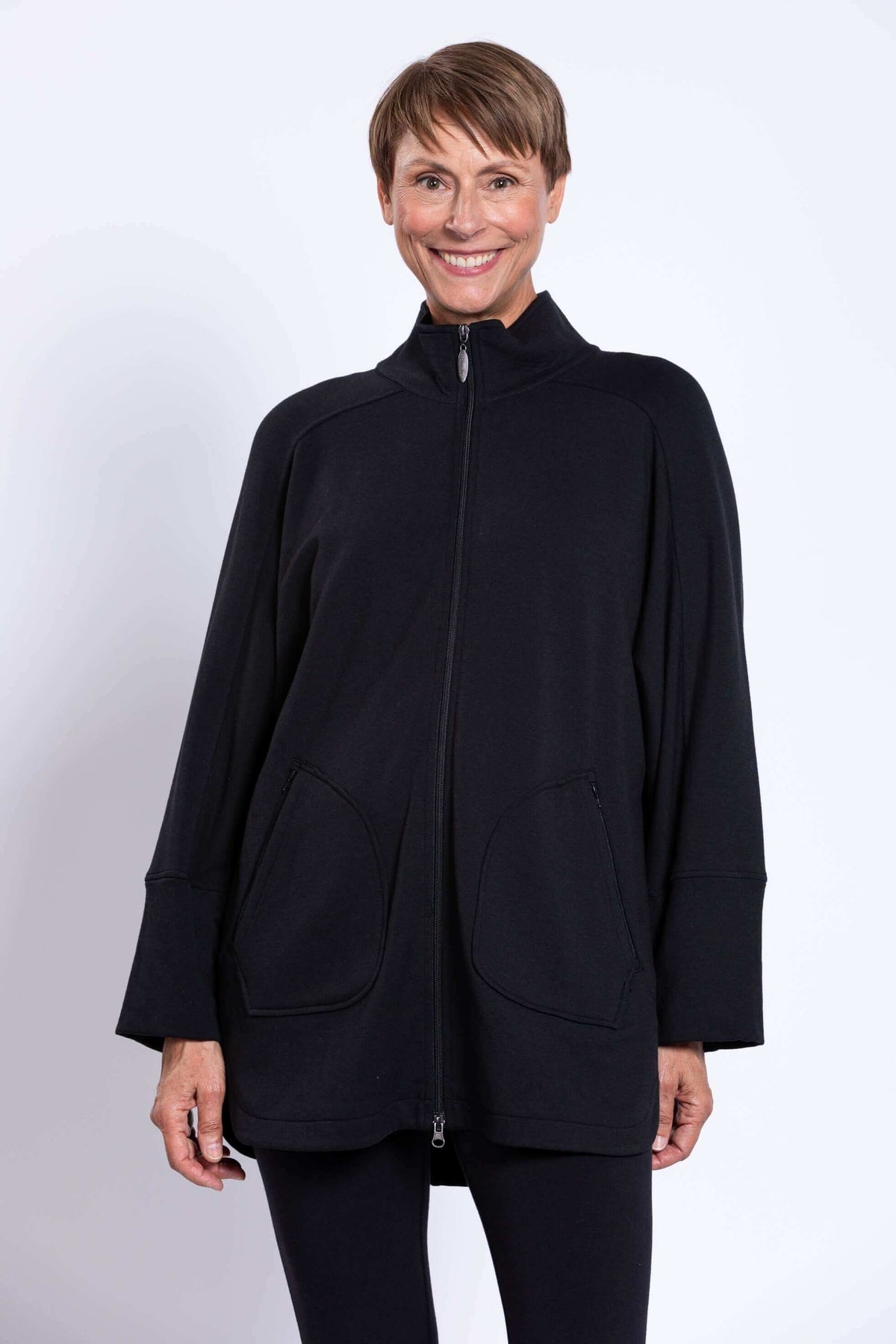 Front view of woman in black jacket with zipper fully closed and two large front pockets
