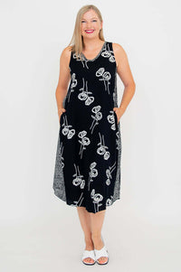 Woman smiling in black midi tank dress with white floral design, front view
