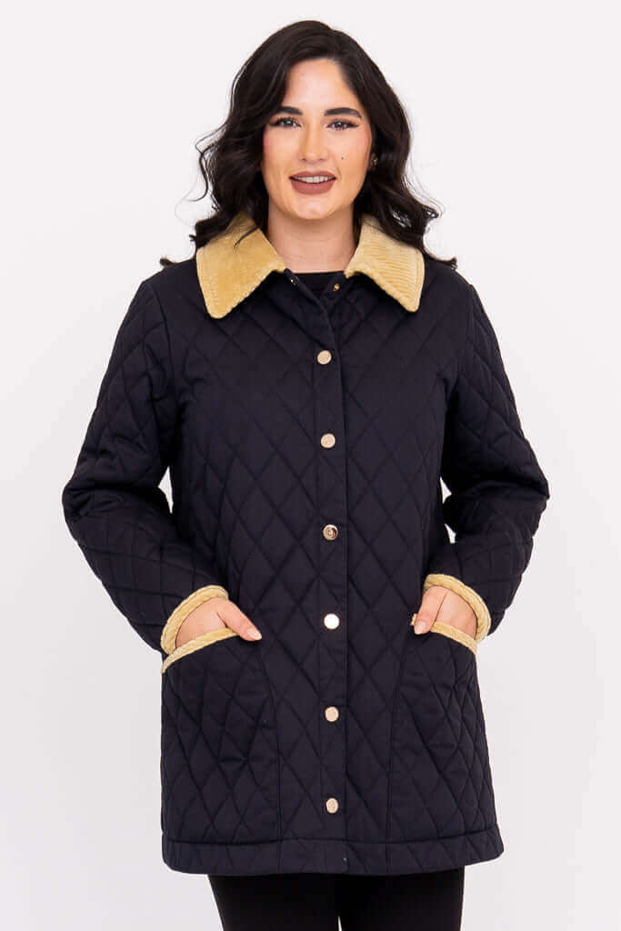 Front view of woman wearing black quilted coat with tan corduroy collar