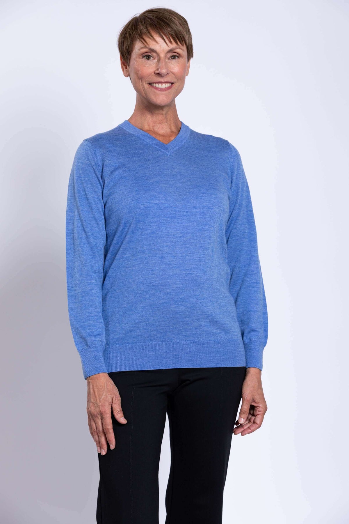 Woman wearing a blue Merino wool V-neck sweater viewed from the front