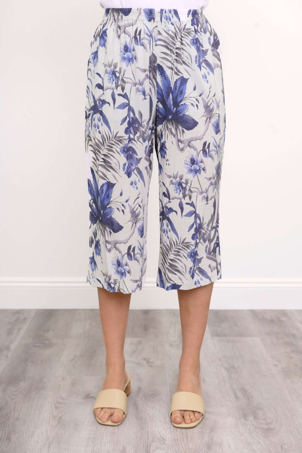Front view of blue and grey floral capri pants on model