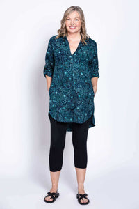 Front view of woman with hands in pockets, wearing blue batik tunic blouse