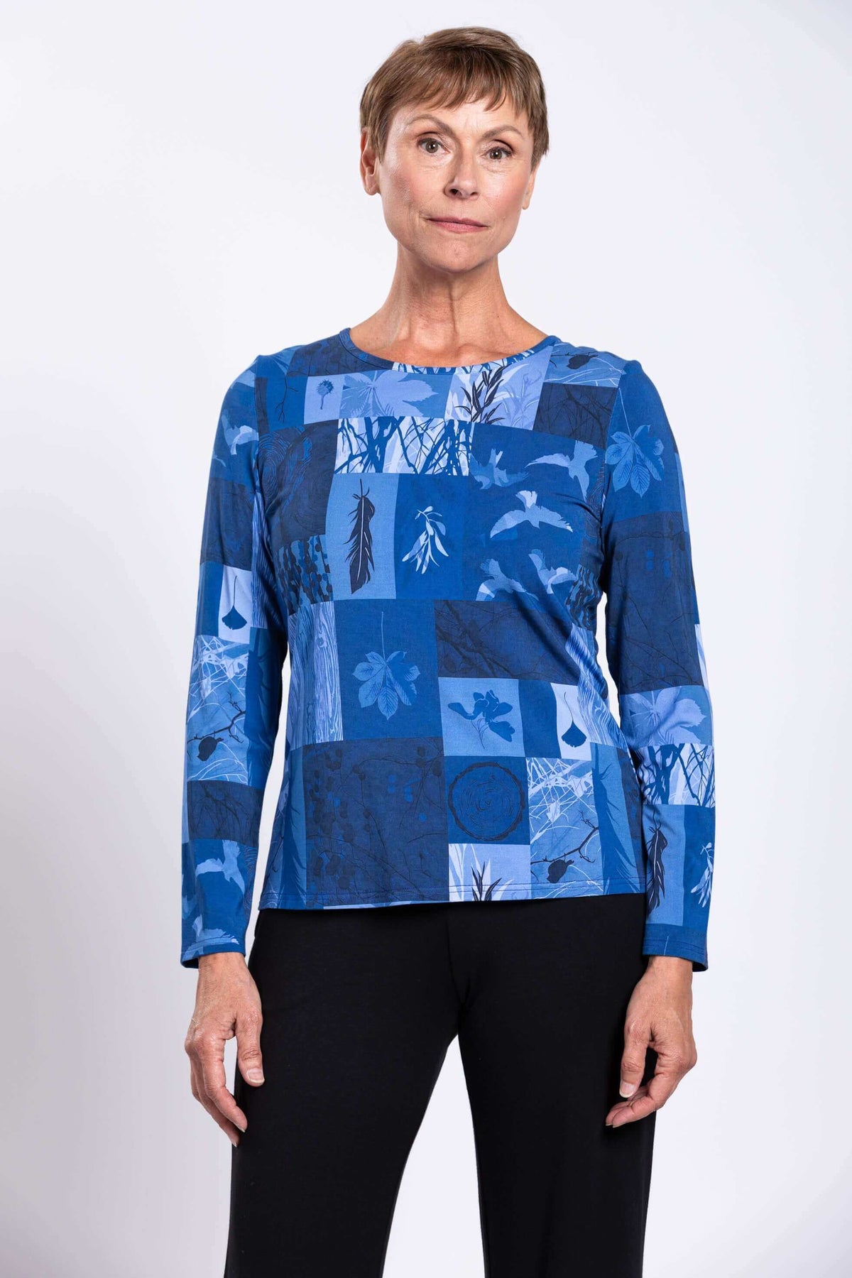 Woman wearing long sleeve blue botanical patchwork top front view