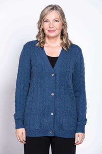 Front view of woman wearing a blue cable knit cardigan with V-neck and pockets