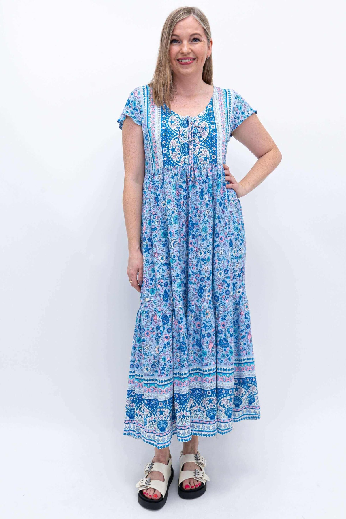 Front view of woman wearing a blue floral Sharpie Dress with flutter sleeves