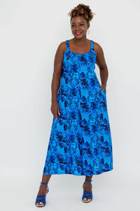 Front view of woman wearing a blue floral jumpsuit with pockets
