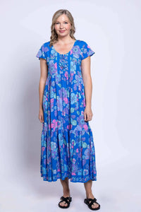 Front view of a woman wearing a blue floral tiered dress with short flutter sleeves