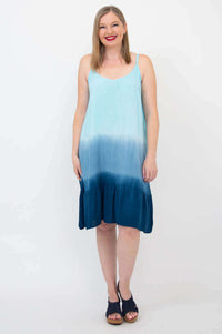 Front view of woman wearing a sleeveless blue ombre knee-length tiered dress
