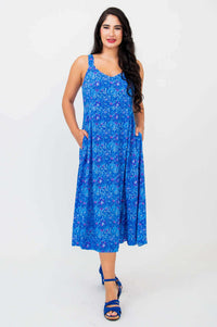 Front view of woman in sleeveless blue midi dress with A-line skirt and pockets