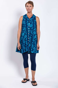 Front view of woman wearing blue sleeveless floral button-up tank dress with leggings