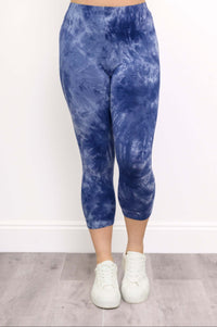 Front view of blue tie-dye capri leggings with white sneakers