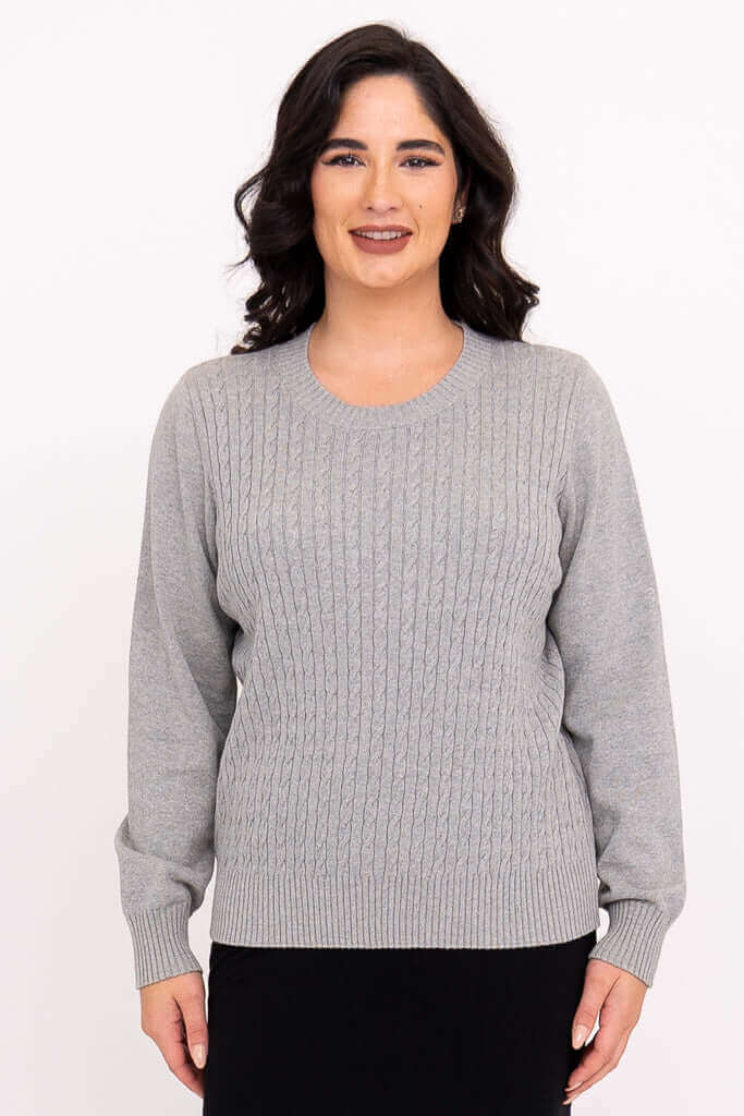 Front view of woman wearing classic grey cable knit sweater
