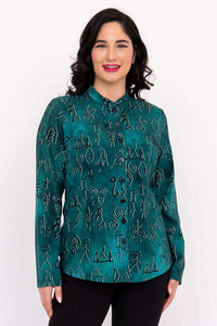 Front view of woman wearing emerald green button-up top with abstract pattern