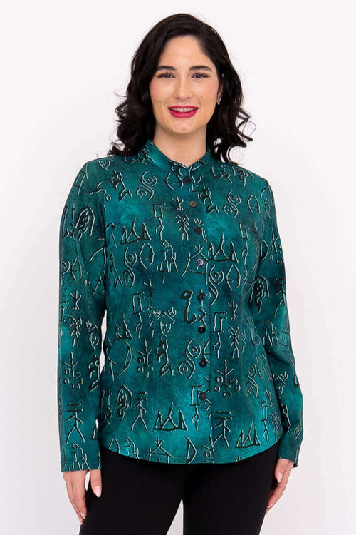 Front view of woman wearing emerald green button-up top with abstract pattern