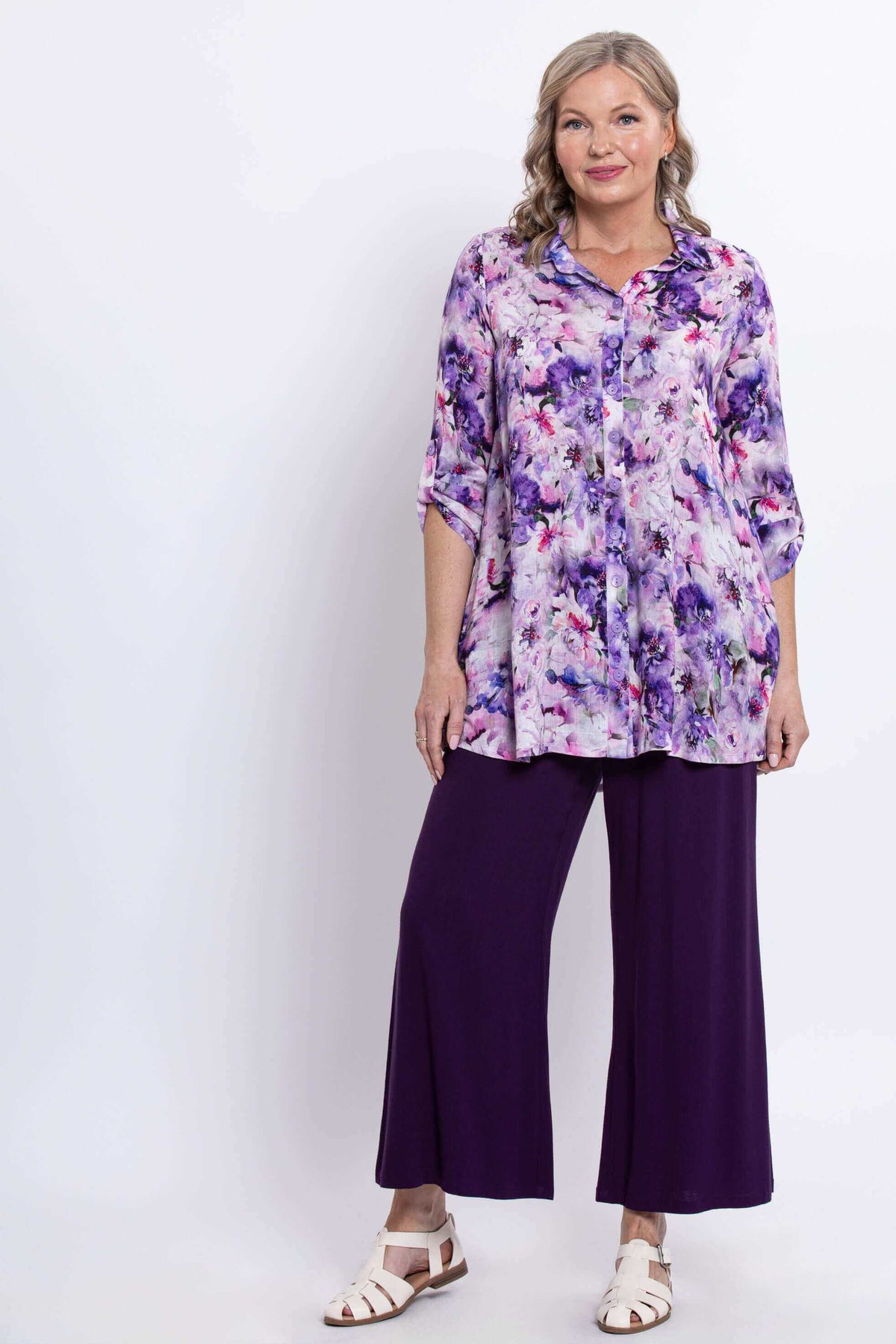 Front view of woman in floral bamboo-linen tunic and purple pants