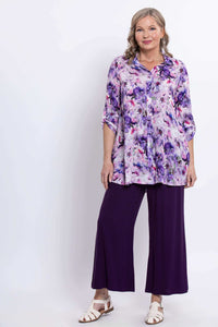 Front view of woman in floral bamboo-linen tunic and purple pants