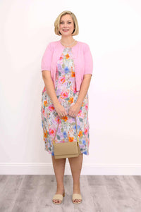 Front view of floral shift dress with pink cardigan and pearl necklace