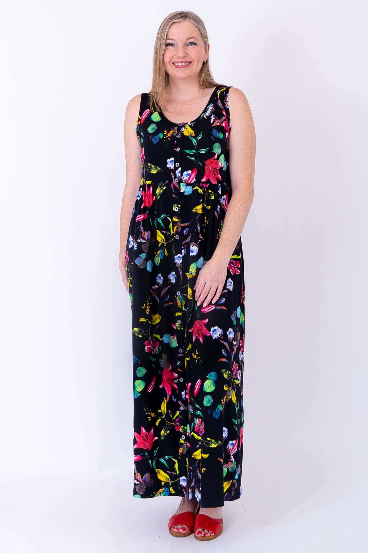 Front view of floral sleeveless maxi dress in black, modeled with hands by her side