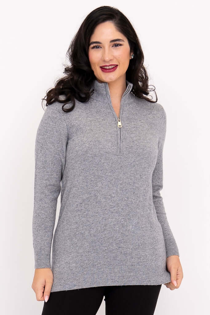 Front view of a woman wearing a grey mock neck zip sweater