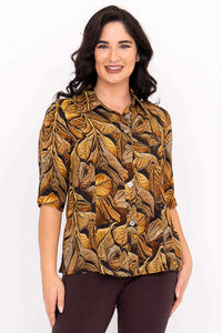 Woman wearing a button-up bamboo-linen blouse with bold leaf print, front view