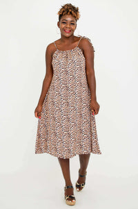 Front view of a woman wearing a leopard print tie-shoulder beach dress