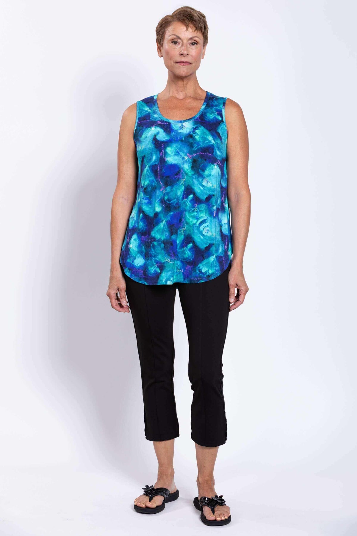 Front view of model in Jazz Tank in oceanic blue print with black capri pants