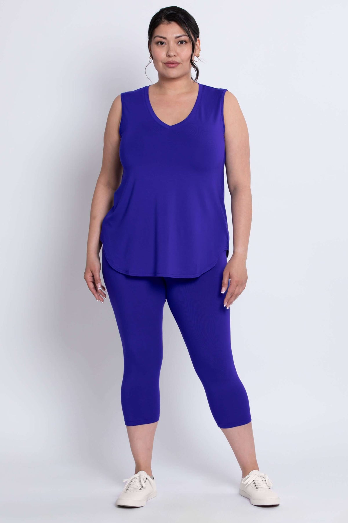 Model wearing vibrant blue capri leggings and sleeveless top, front view