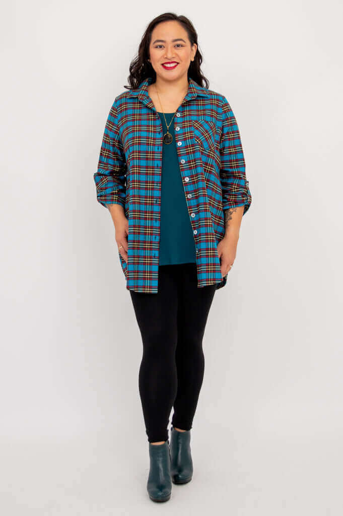 Front view of model in blue plaid flannel tunic, hands relaxed at sides