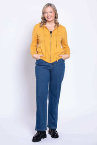 Front view of a woman wearing classic fit straight leg blue jeans with a yellow hoodie.