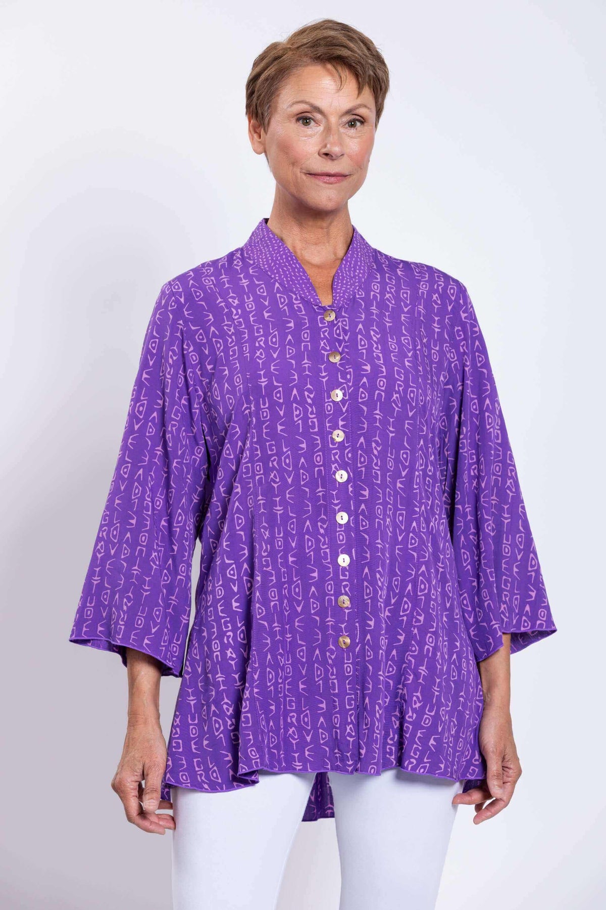 Front view of model wearing violet Mar blouse with button front and subtle abstract print