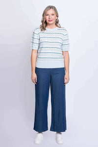 Front view of woman in light blue knit Sweater paired with wide-leg blue pants